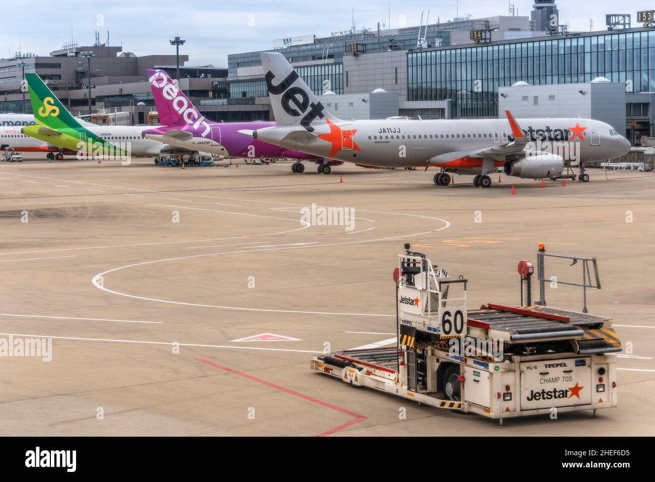 tokyo, japan - december 06 2021: Trepel cargo high loader with Boeing and airbus planes from the three most famous Japanese low-cost airlines parked o Stock Photo
