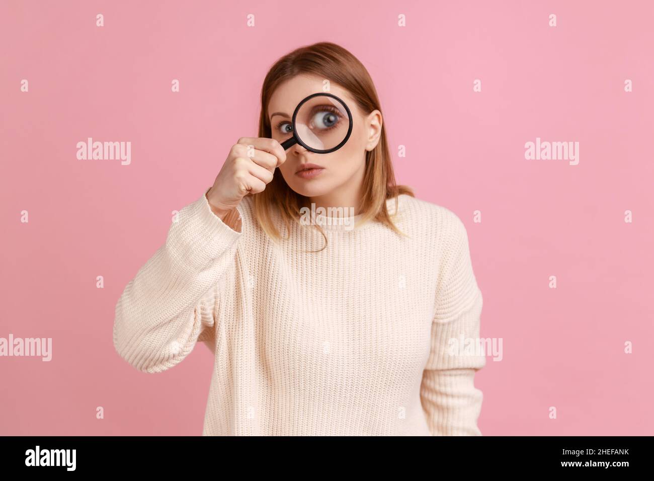 Woman looking through a giant magnifying glass Stock Photo