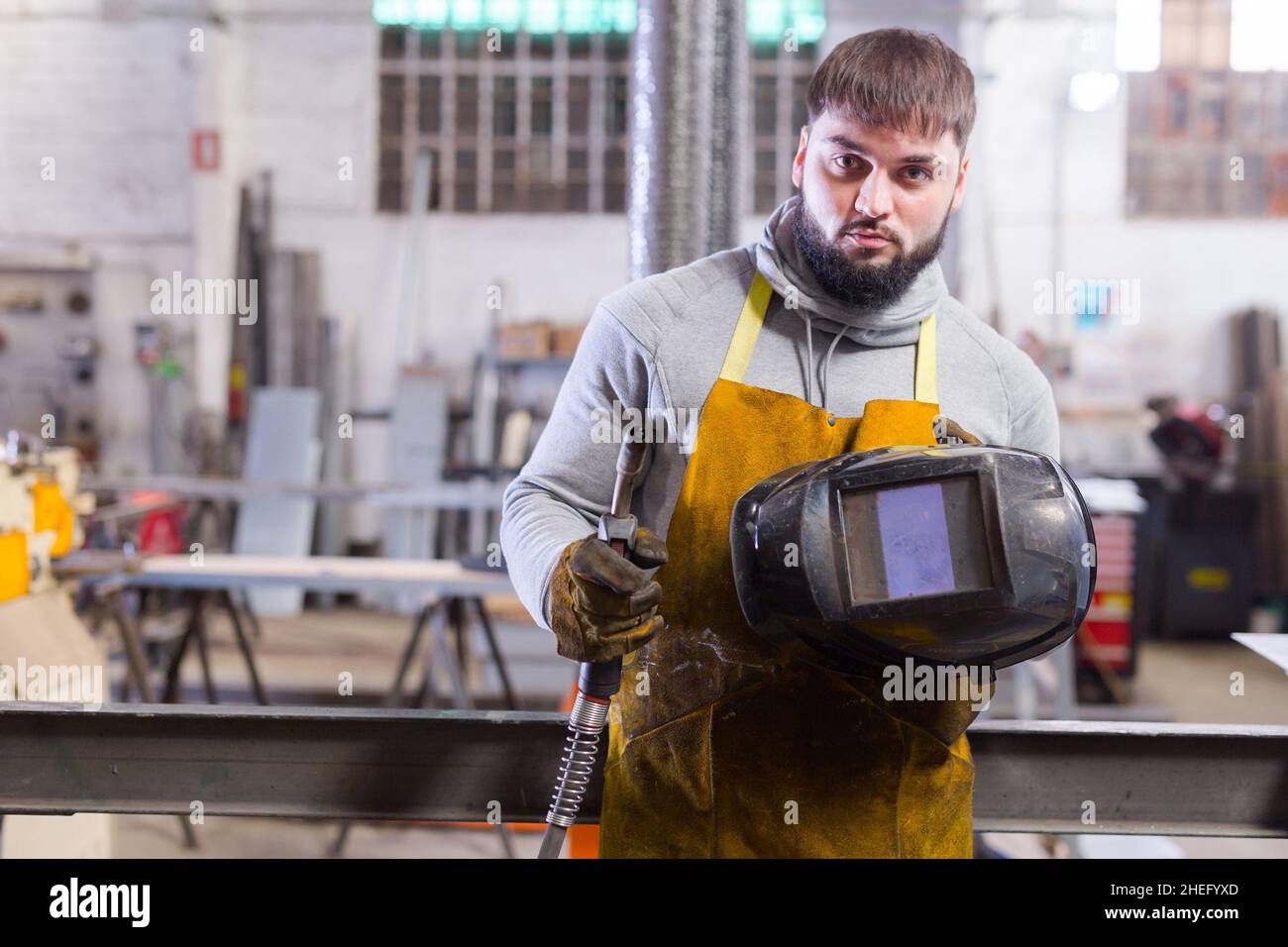 Man using welder for construction work at the workshop Stock Photo