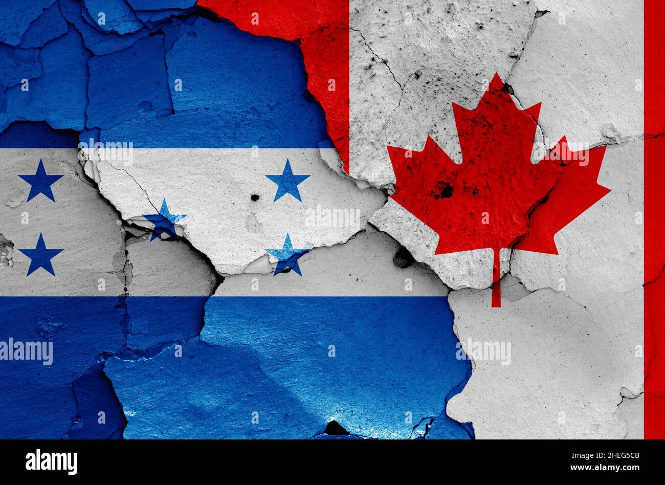 flags of Honduras and Canada painted on cracked wall Stock Photo