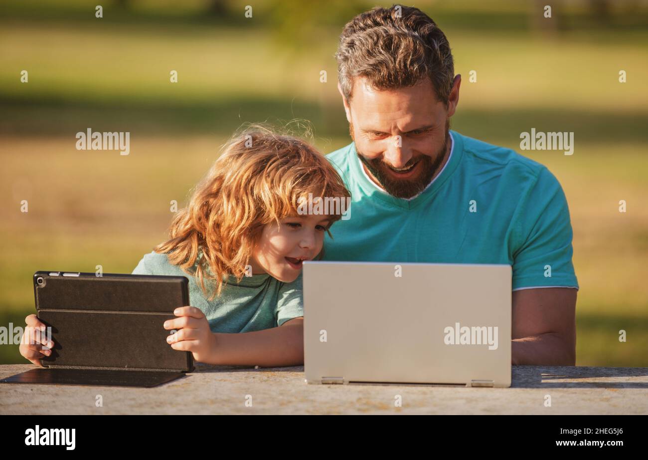 Happy father using laptop relax with schooler son holding laptop have ...