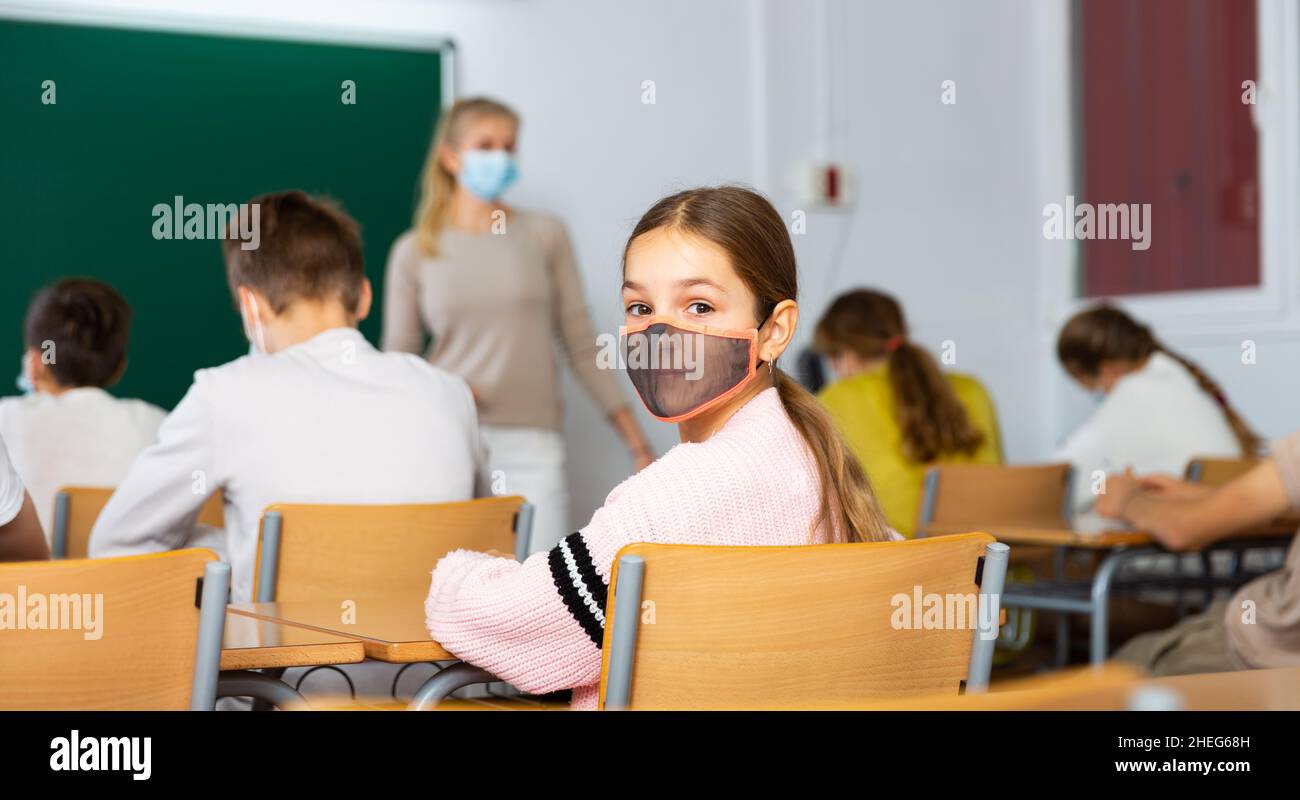 Study Mask Student in protective mask studying in classroom, listening to lecturer ...