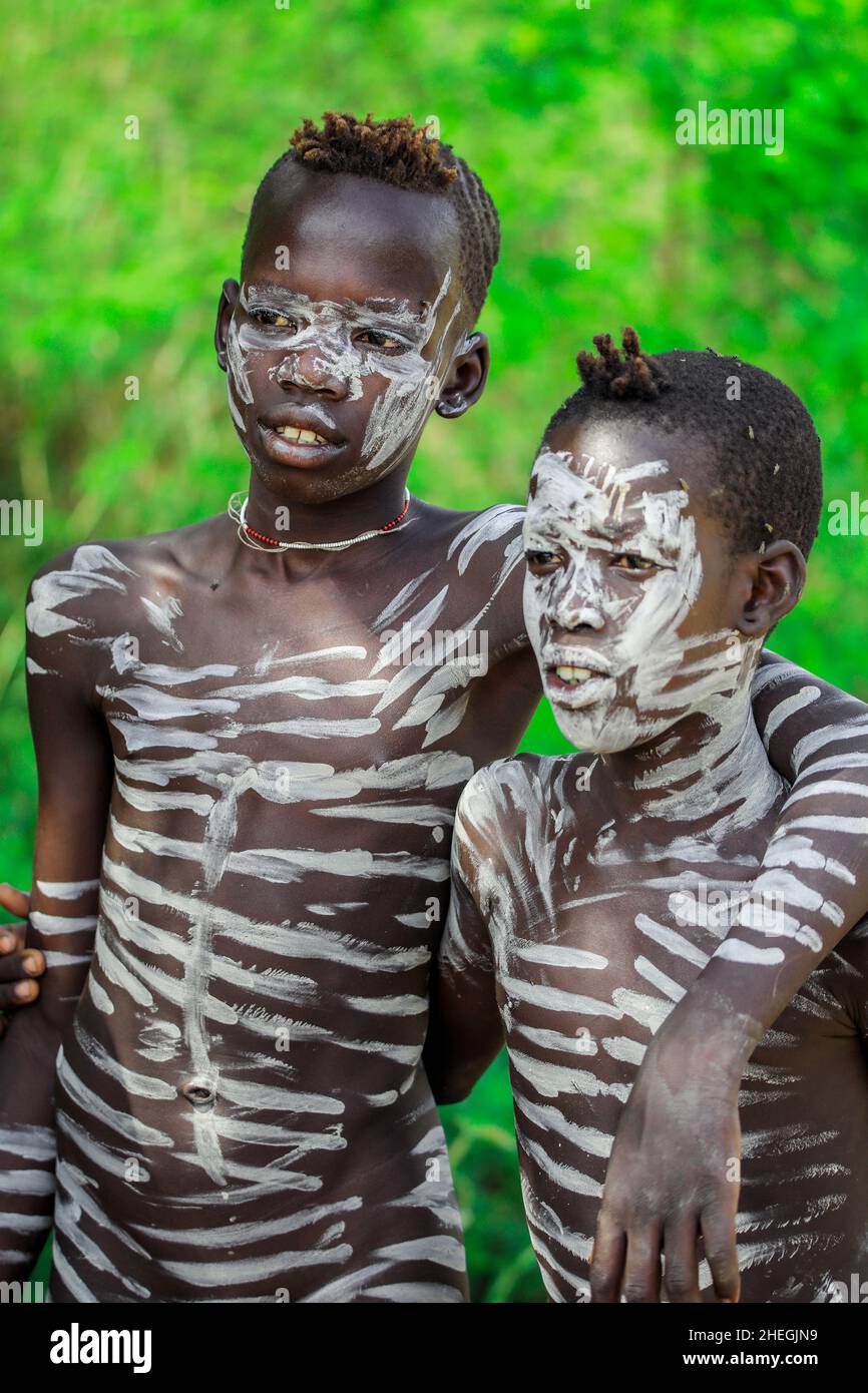 Jinka, Ethiopia - November 30, 2020: Two African Boys with Traditional Tribal Body Painting on the Rural Road Stock Photo