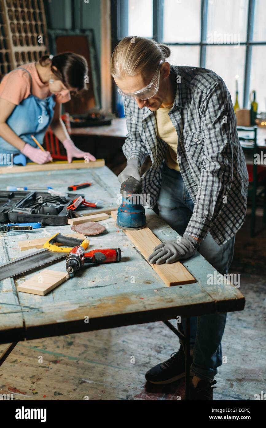 Man and woman working in workshop, doing furniture, reuse old materials ...