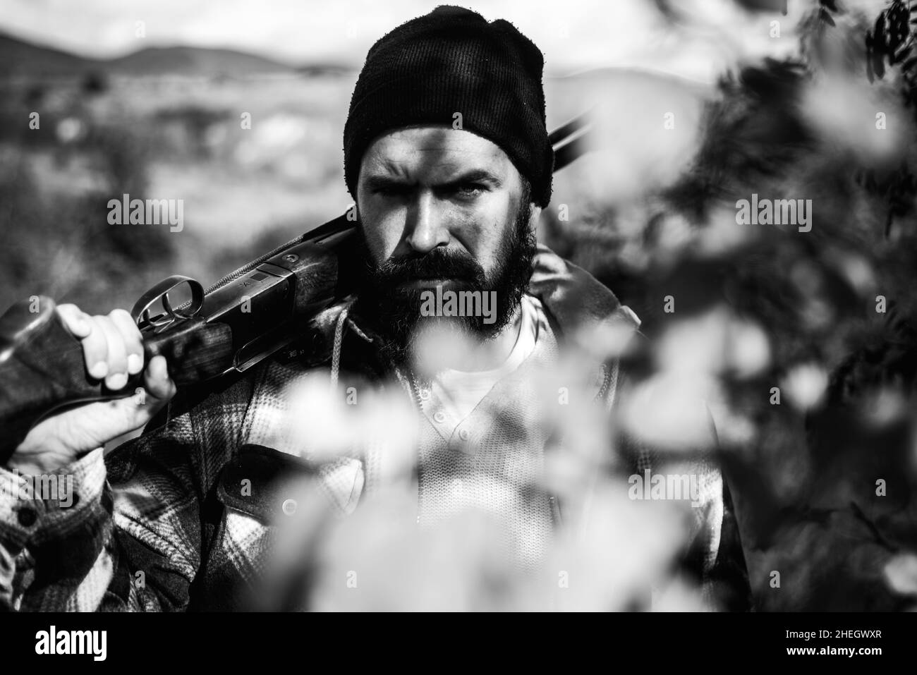 Hunter in the fall hunting season. Calibers of hunting rifles. Man holding shotgun. Hunting in