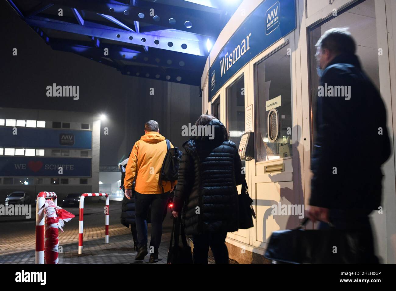 People pass by the entrance of the shipyard at the Wismar location of the MV-Werften shipyards which file insolvency, in Wismar, Germany January 11, 2022. REUTERS/Annegret Hilse Stock Photo