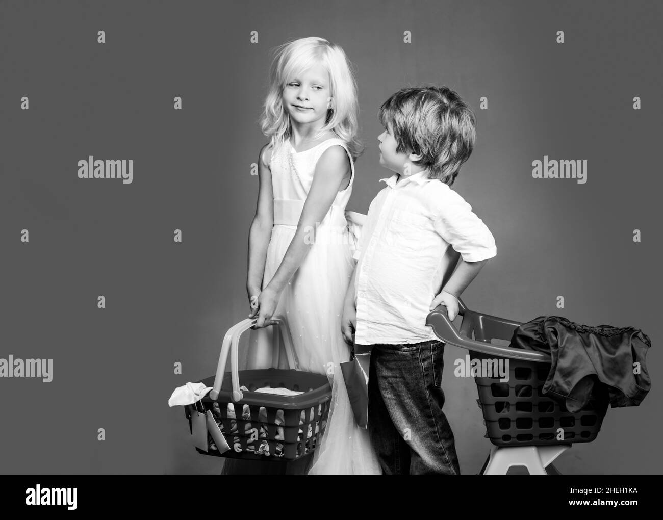 Cute buyer customer client hold shopping cart. Girl and boy children shopping. Couple kids hold plastic shopping basket toy. Kids store. Mall shopping Stock Photo