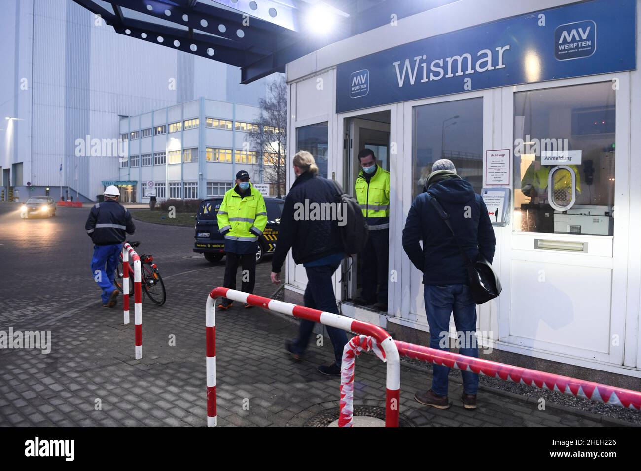 People stand at the entrance of the shipyard at the Wismar location of the MV-Werften shipyards which file insolvency, in Wismar, Germany January 11, 2022. REUTERS/Annegret Hilse Stock Photo
