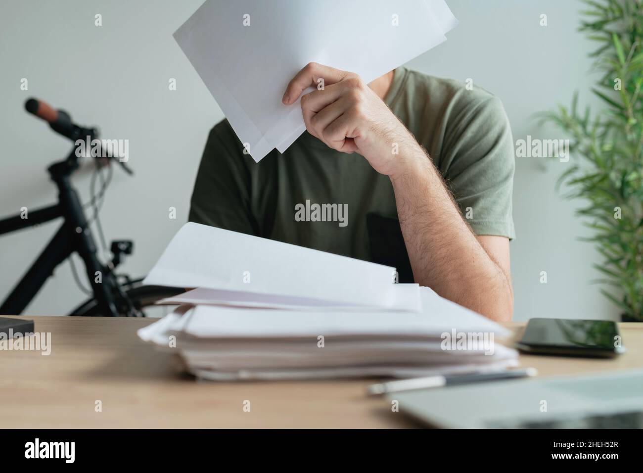 Telecommuter stuck with paperwork in home office, selective focus Stock Photo
