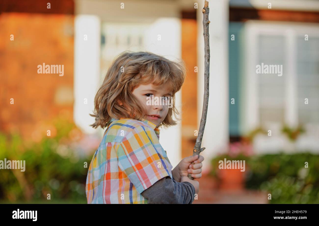 Negative child emotion. Kids aggression. Angry boy with stick. Kid