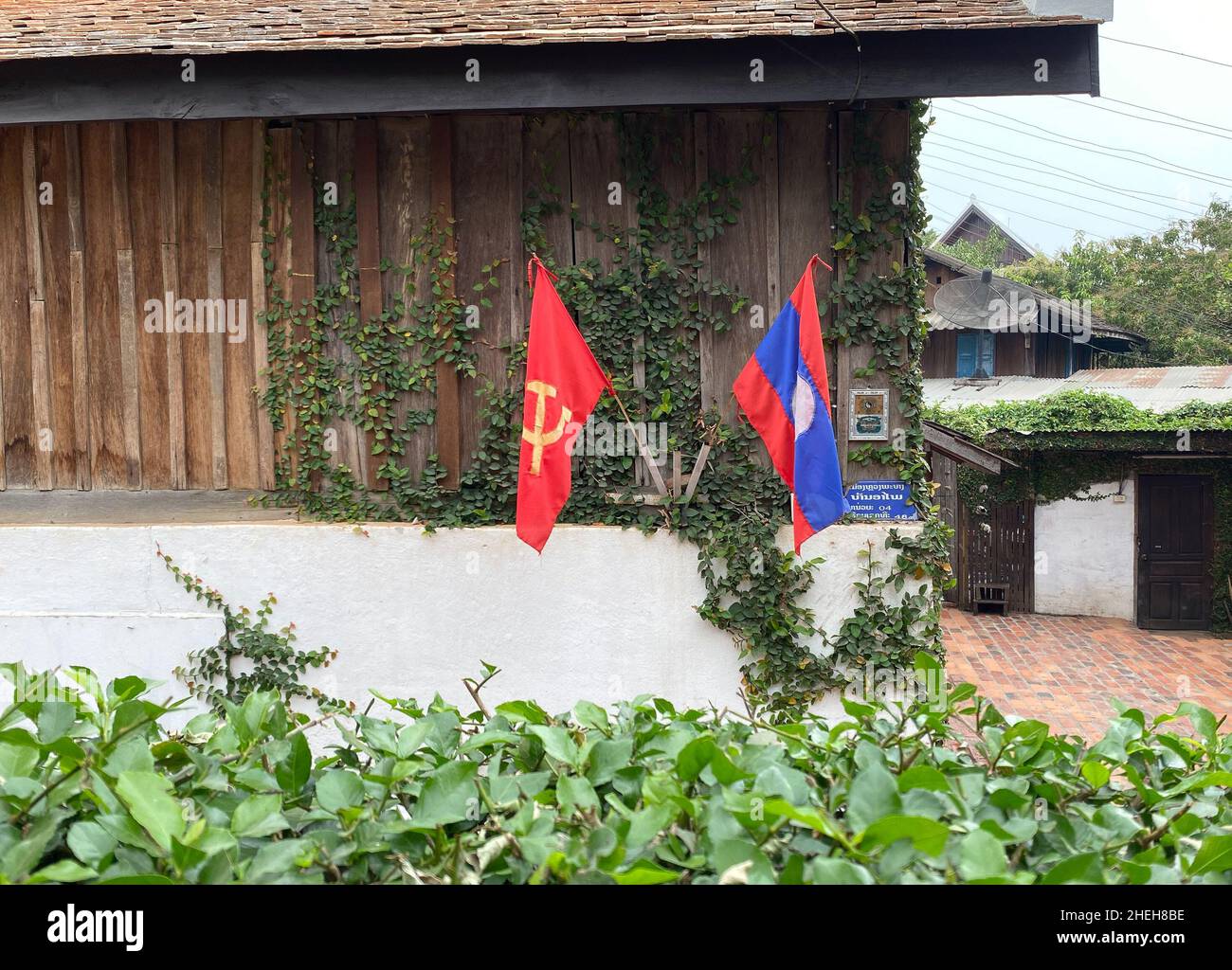Luang Phrabang, Laos - Feb 3, 2020. The Laos national flag hanging in front of the house at old town of Luang Phrabang, Laos. Stock Photo
