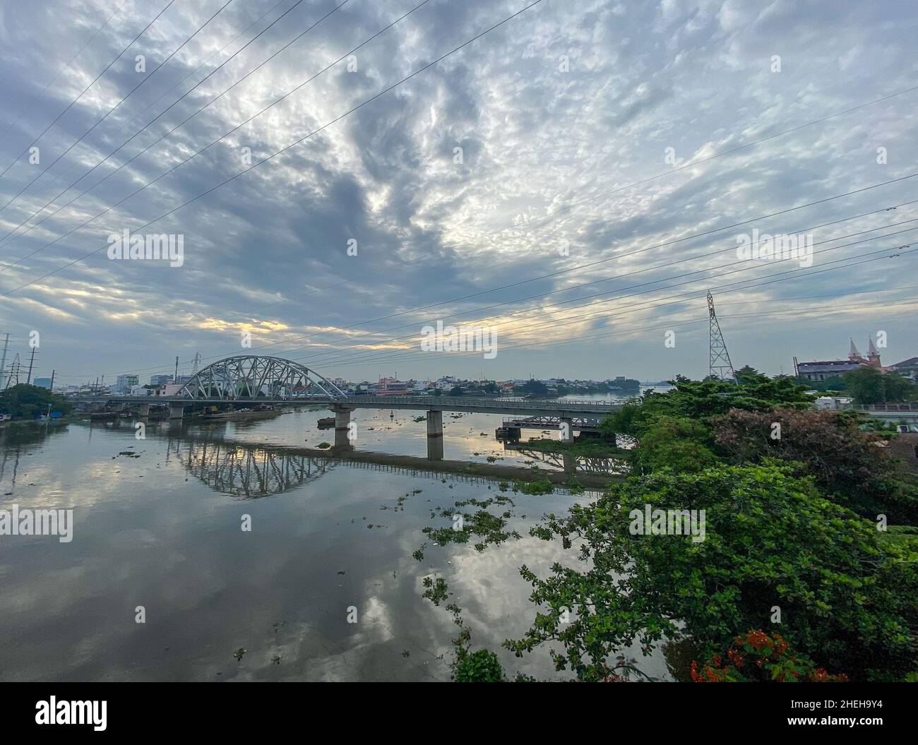 Saigon, Vietnam - Jul 8, 2020. View of Saigon River and Binh Loi railway bridge. Saigon (called Ho Chi Minh city) is the biggest city in Vietnam. Stock Photo