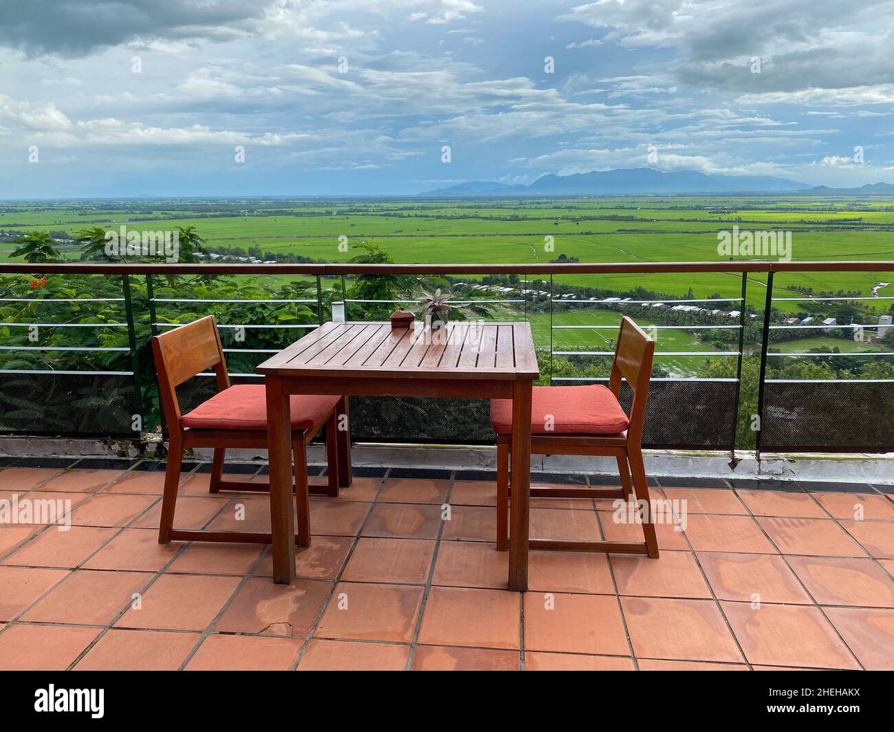 Wooden table and chairs at the coffee shop with mountain view in An Giang, Vietnam. Stock Photo