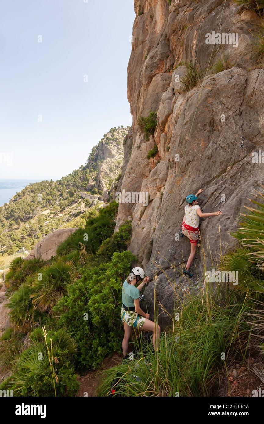 Family rock climbing at C'an Ortigues climbing area, Cala de ses ortigues, Mallorca, Spain Stock Photo