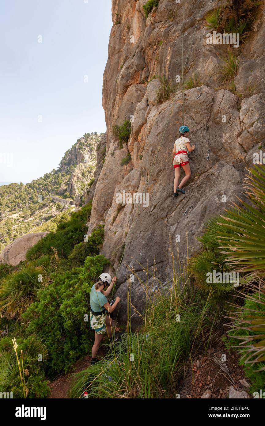 Family rock climbing at C'an Ortigues climbing area, Cala de ses ortigues, Mallorca, Spain Stock Photo