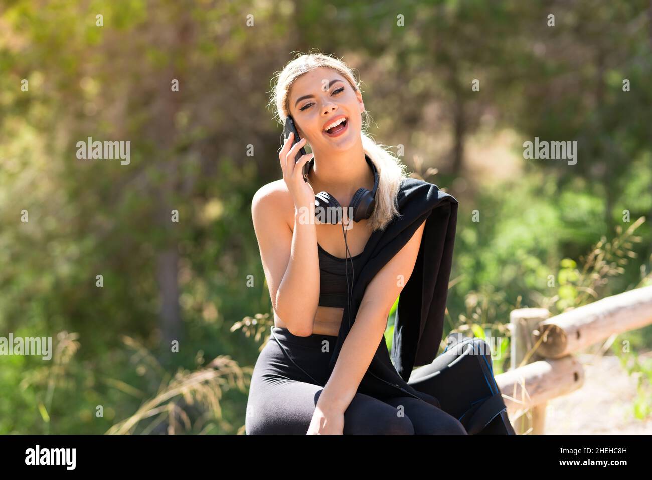 Teenager sport girl doing sport at outdoors keeping a conversation with the mobile phone Stock Photo