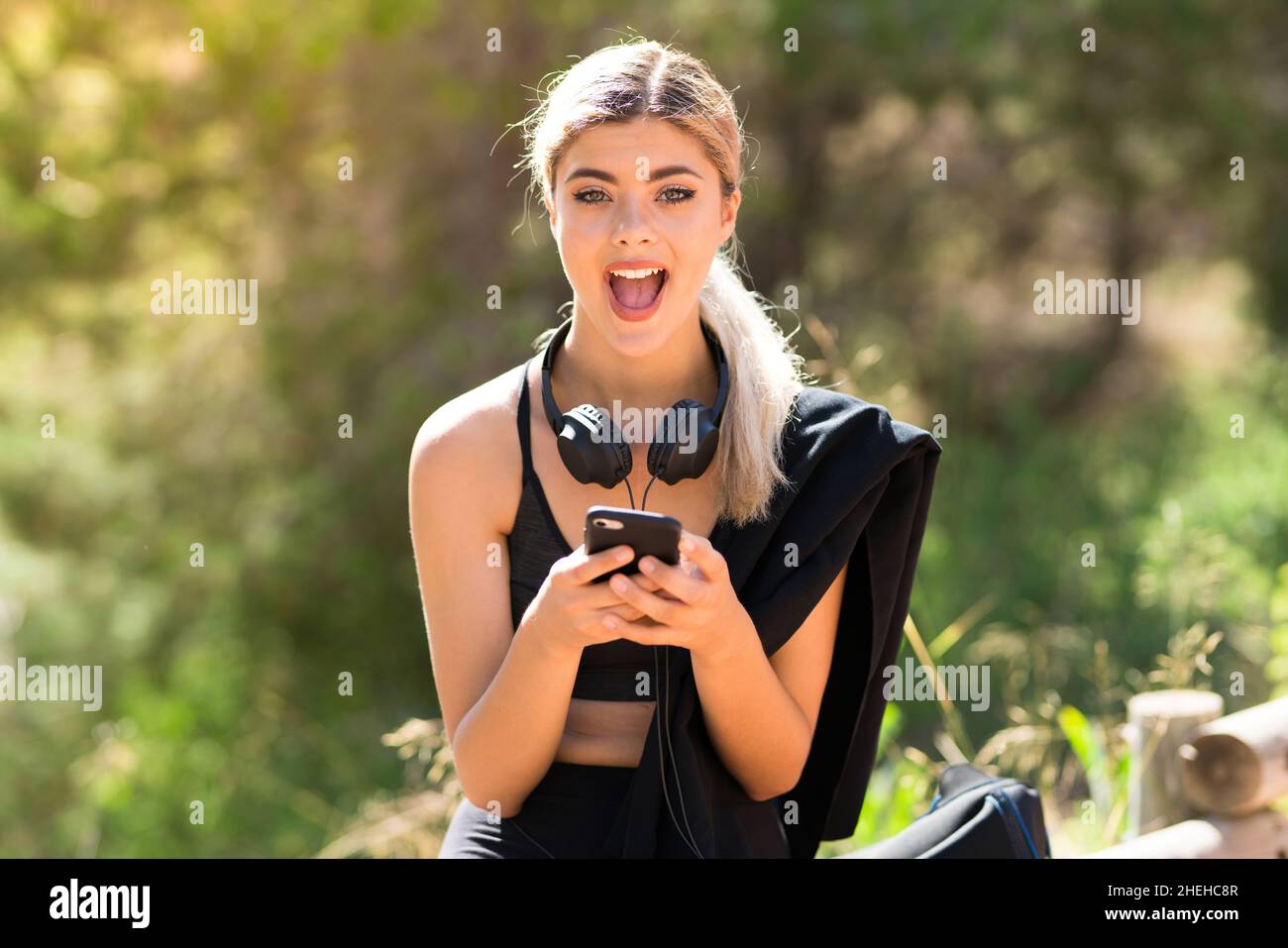 Teenager sport girl doing sport at outdoors surprised and sending a message Stock Photo