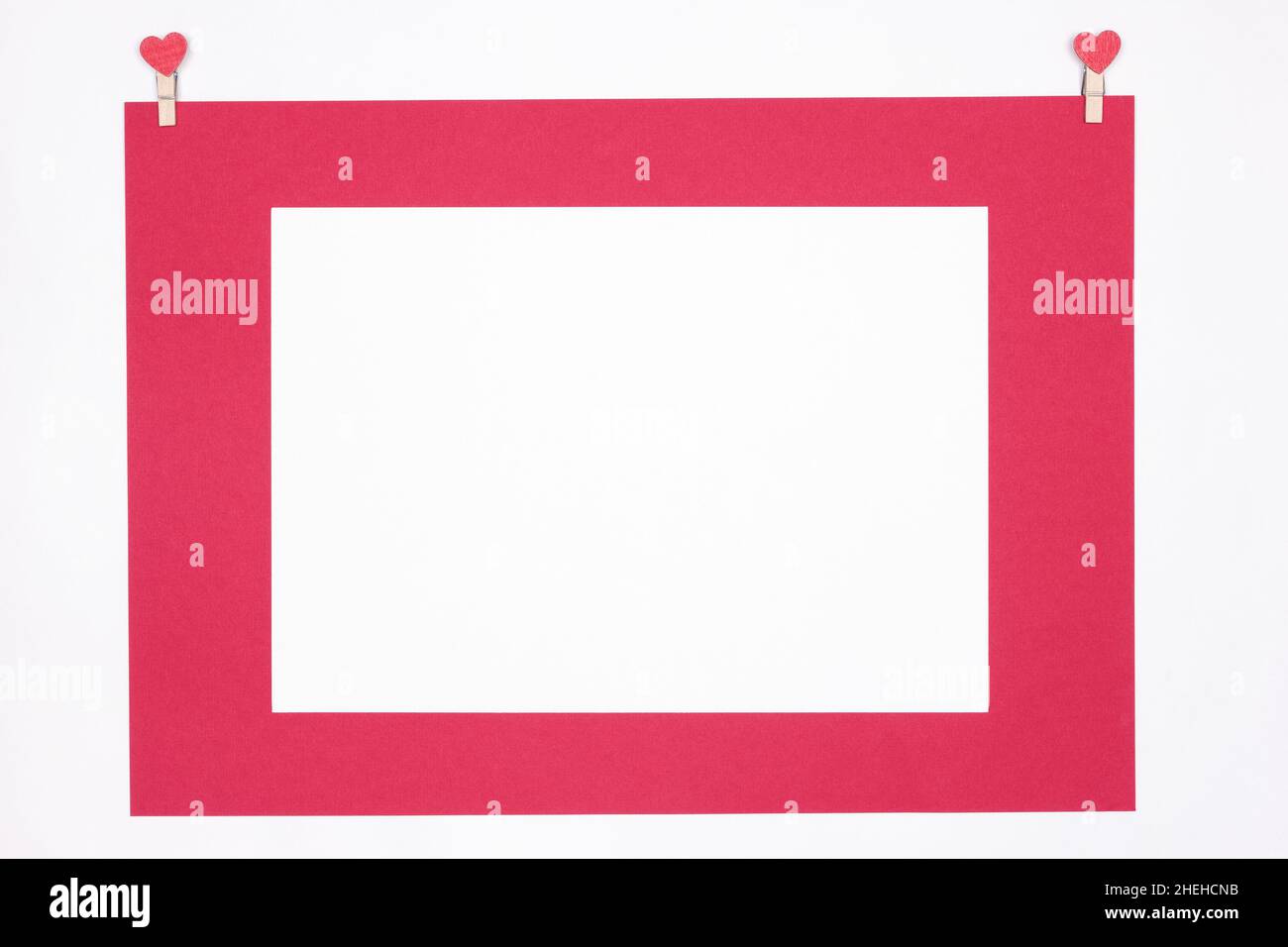 Blank white paper with red frame and heart shaped pins. Copy space ...