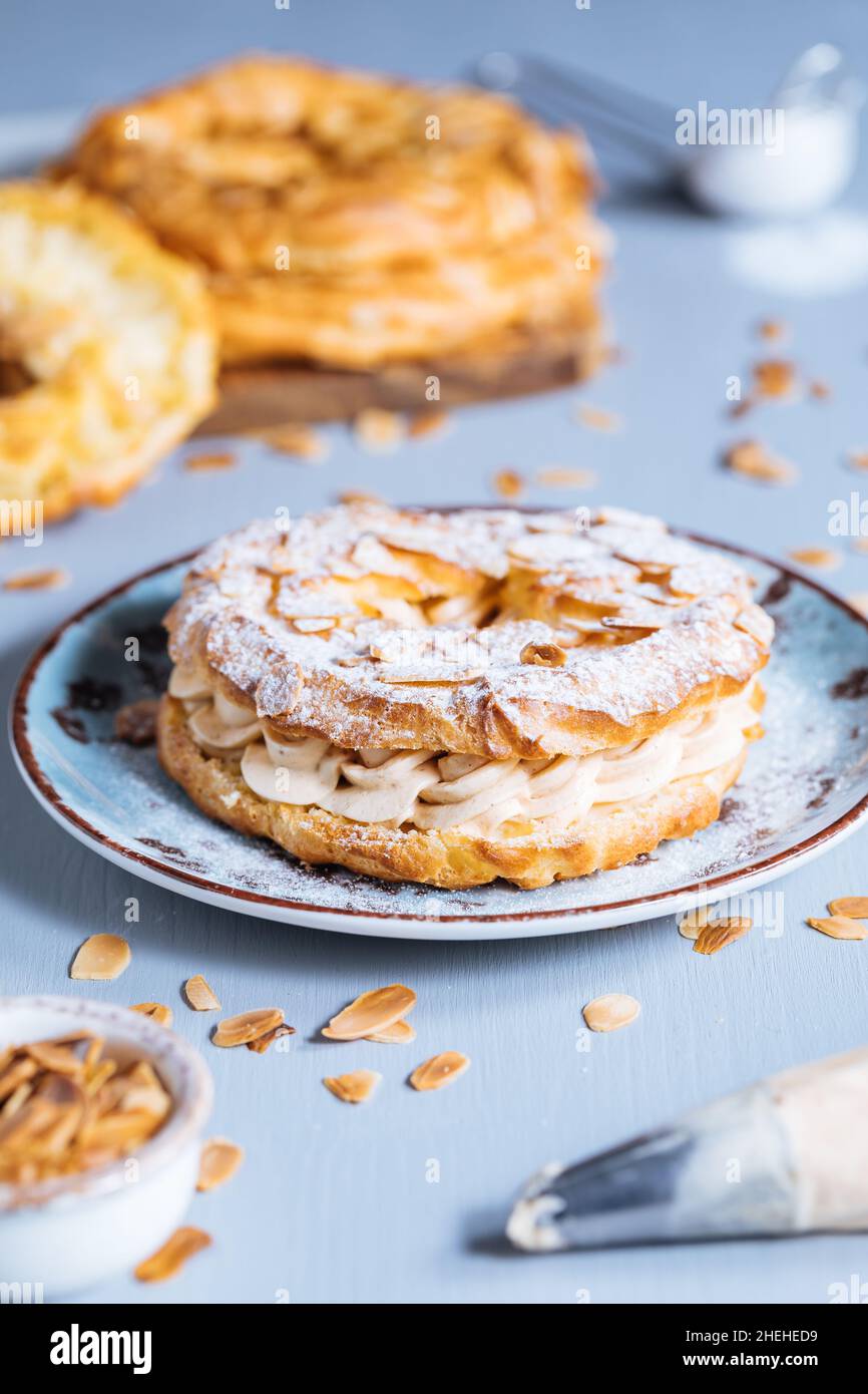 Traditional french Dessert called Paris Brest on a grey background with powder sugar and almond
