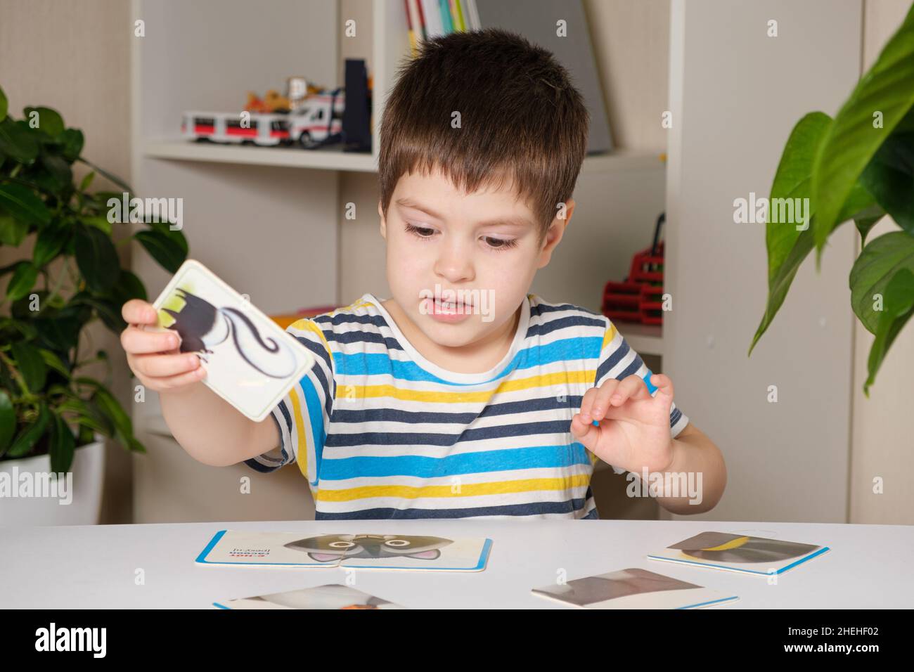 A 4yearold boy puts together a picture of a raccoon from puzzles