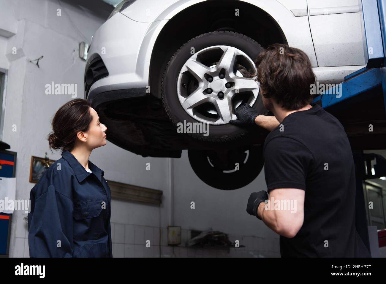 Mechanics working with car wheel in service Stock Photo Alamy
