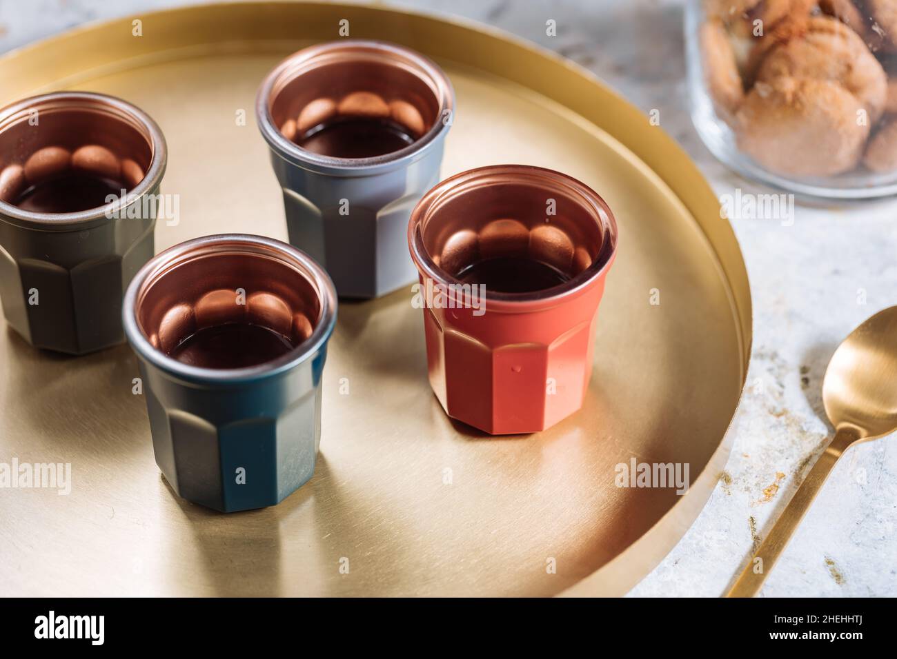 Espresso coffee shots in four different cups on a golden tray with