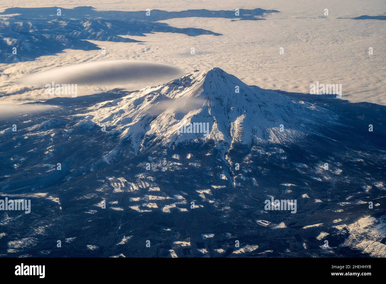 Winter aerial view over Mount Shasta adorned with a lenticular cloud, California, USA Stock Photo