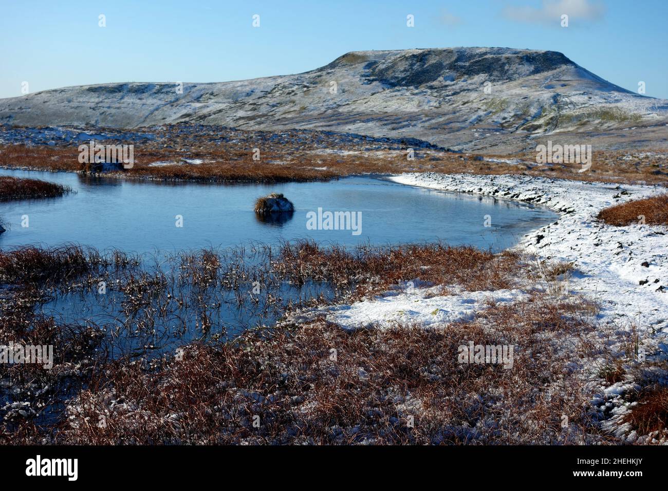 The Icy Summit Ingleborough (1 of the Yorkshire 3 Peaks) from a Frozen Tarn near the Path on Simon Fell, Yorkshire Dales National Park, England, UK. Stock Photo