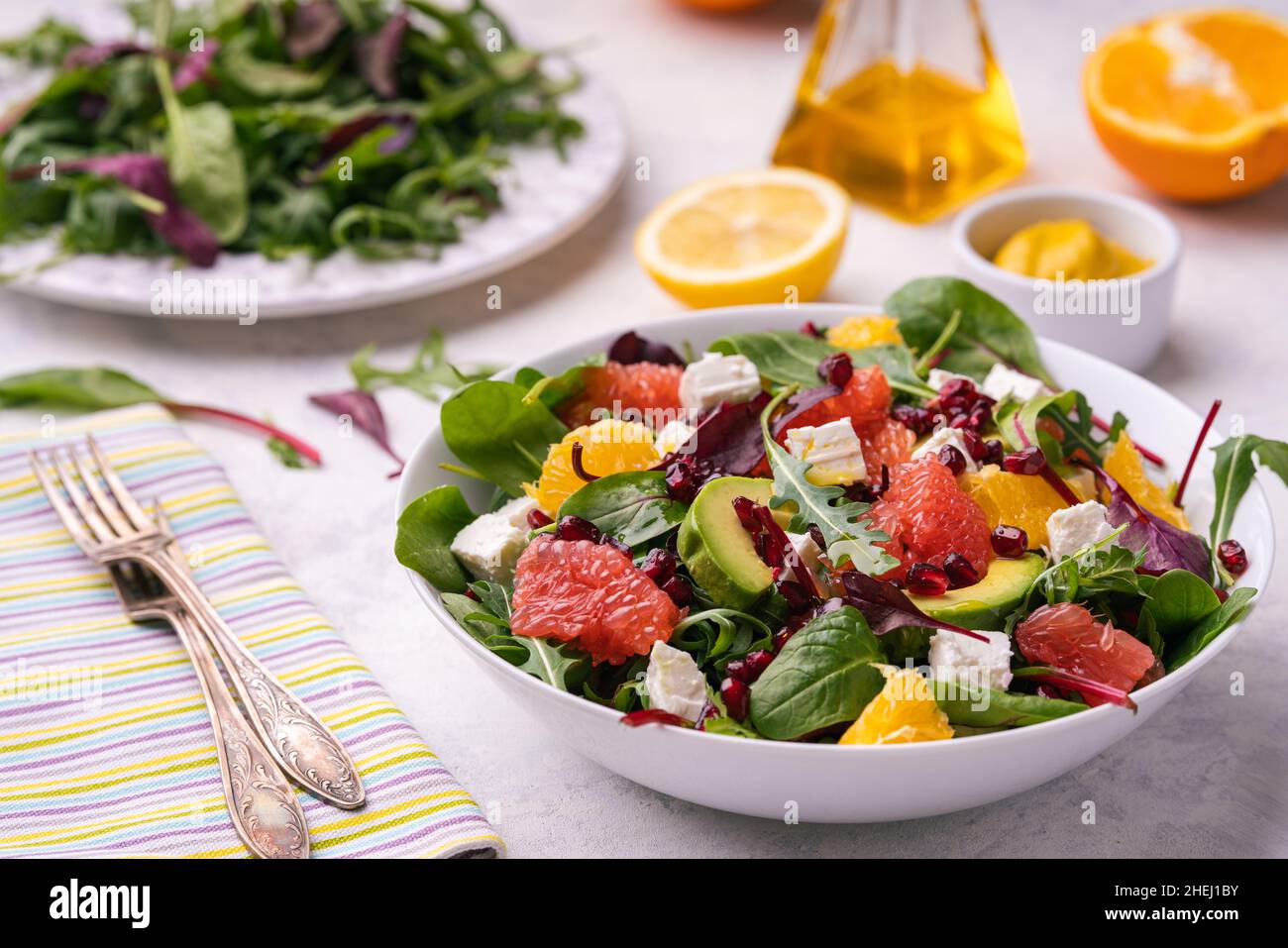 Healthy orange, avocado, grapefruit and pomegranate salad with honey