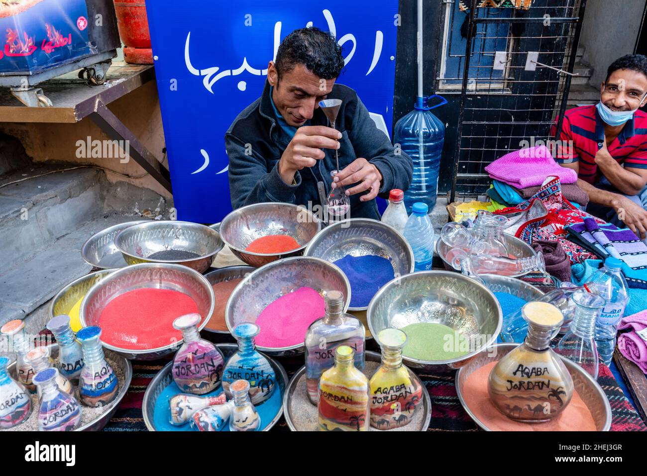 A Sand Artist Preparing Colourful Sand Bottles, Aqaba, Aqaba Governorate, Jordan. Stock Photo