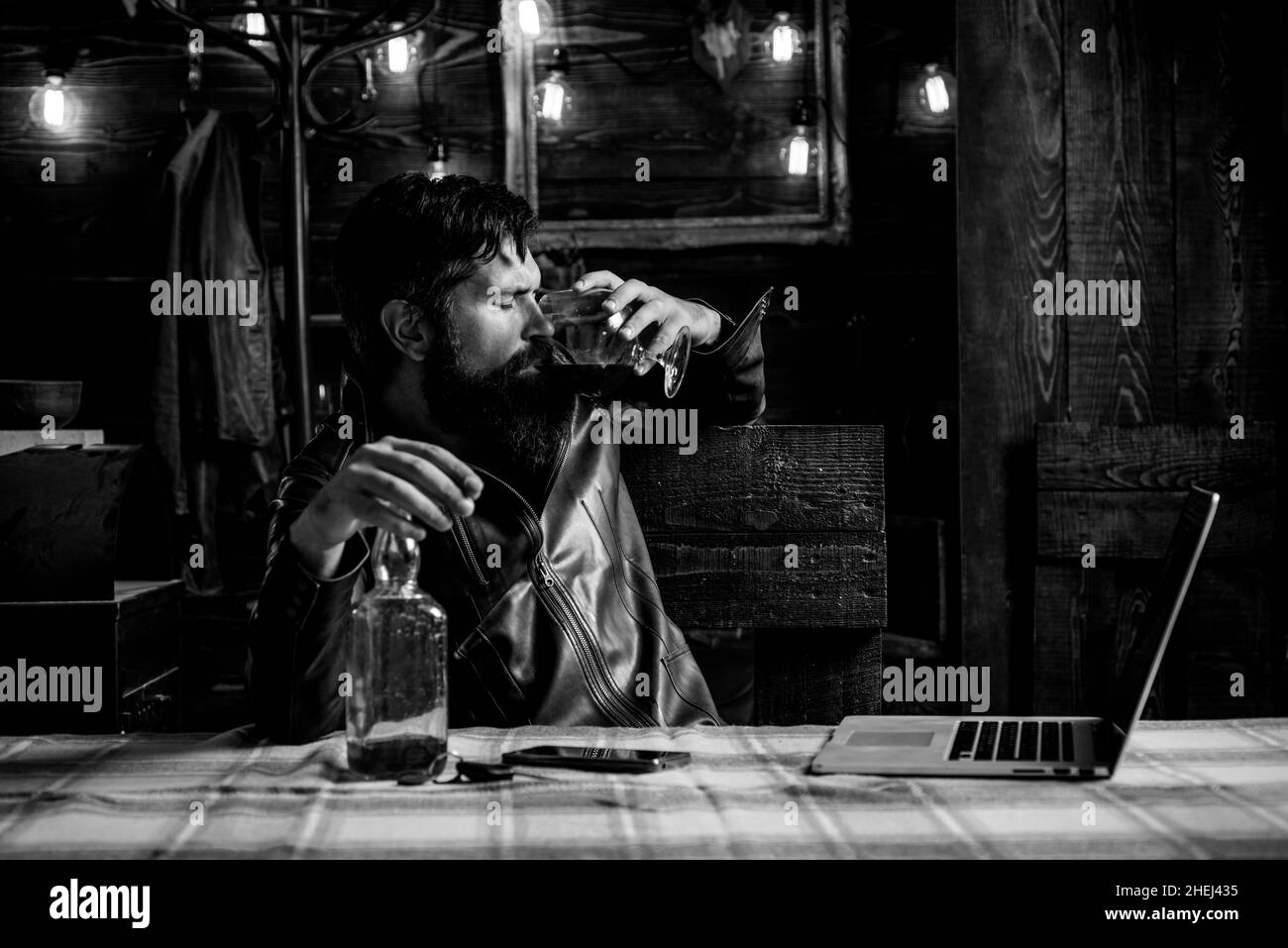 Drinking man. Man with beard holds glass brandy. Man holding a glass of whisky. Sipping whiskey. Degustation, tasting. Macho is drinking whiskey Stock Photo