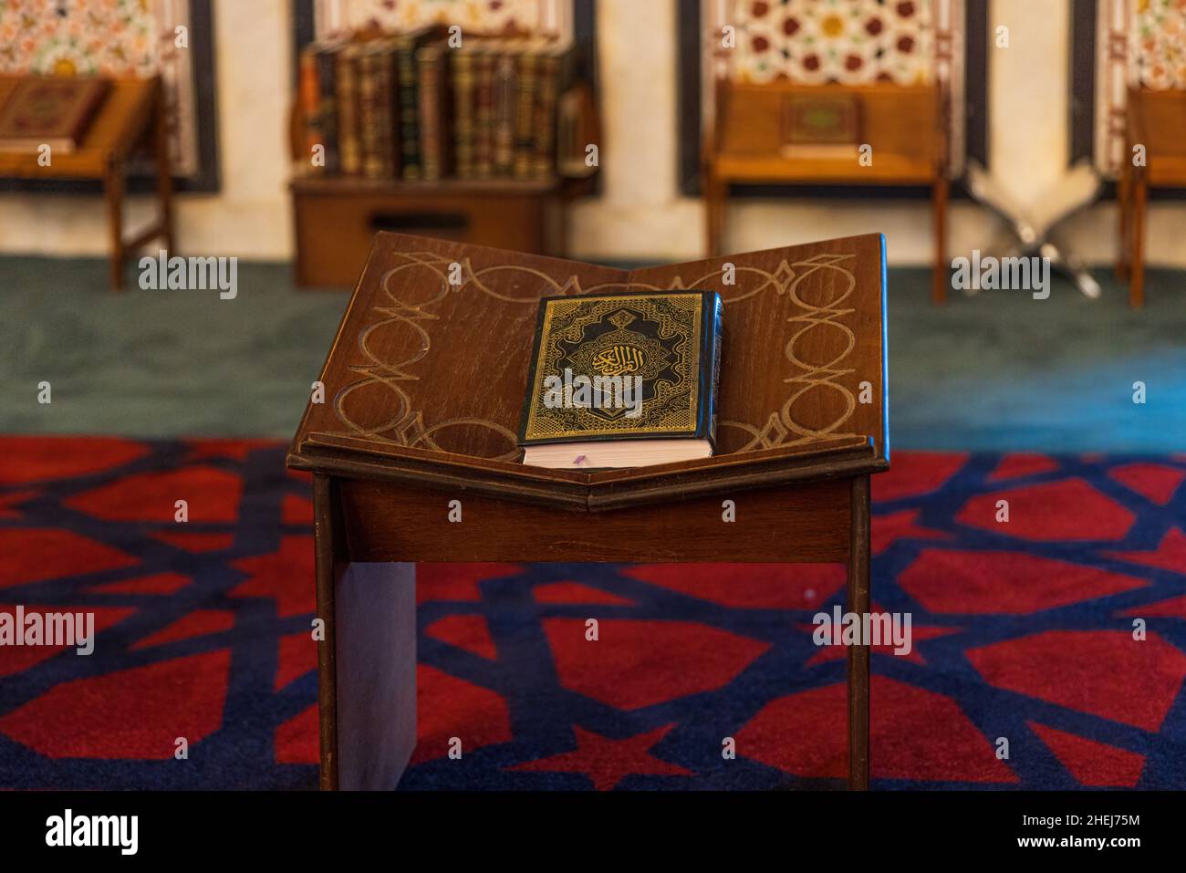 AMMAN, JORDAN - SEPTEMBER 27, 2021: Holy Quran with Al Quran Al Kareem Islamic Calligraphy on a bookstand inside the prayer hall of the Mosque of King Stock Photo