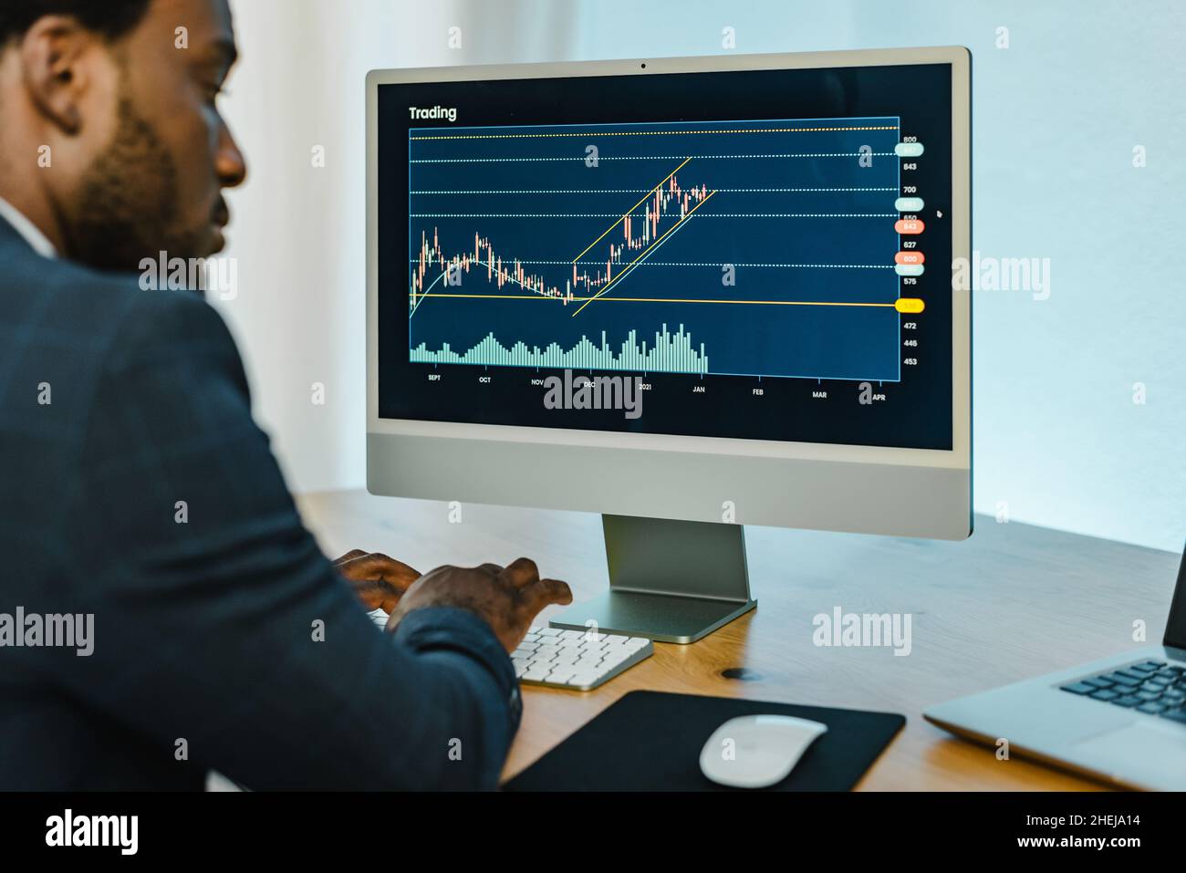 Black man analyzing financial diagrams on binary option Stock Photo