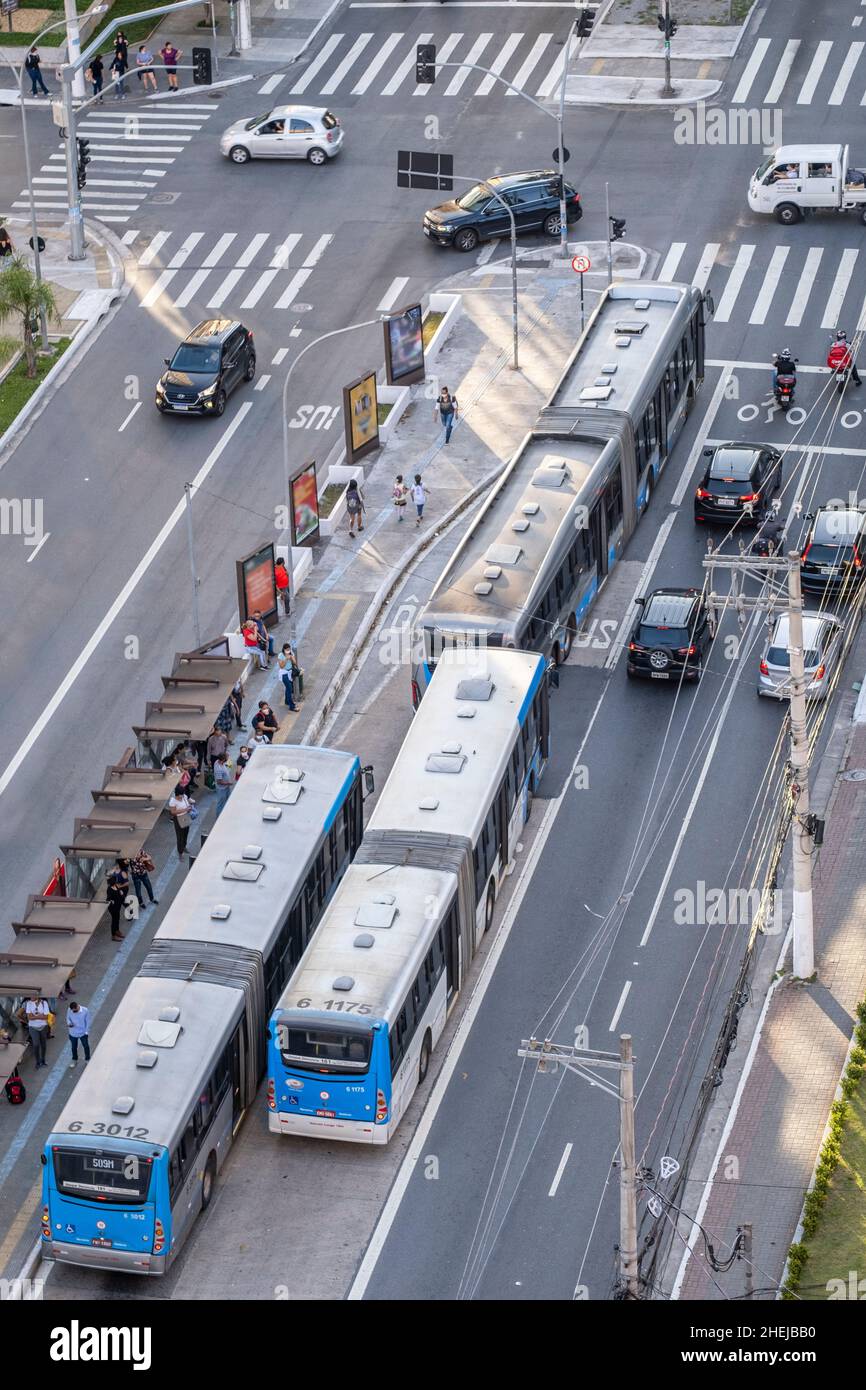 Articulated buses on a busy urban highway. BRT (Bus Rapid Transit) articulated bus in a BRT bus lane. Passengers at bus stop. Sao Paulo, Brazil Stock Photo