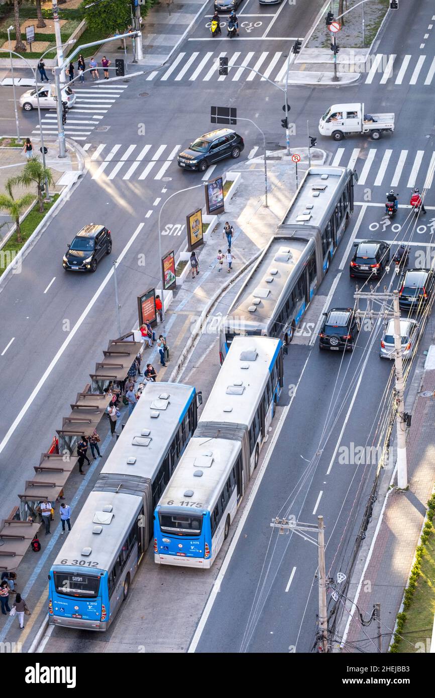 Articulated buses on a busy urban highway. BRT (Bus Rapid Transit) articulated bus in a BRT bus lane. Passengers at bus stop. Sao Paulo, Brazil Stock Photo