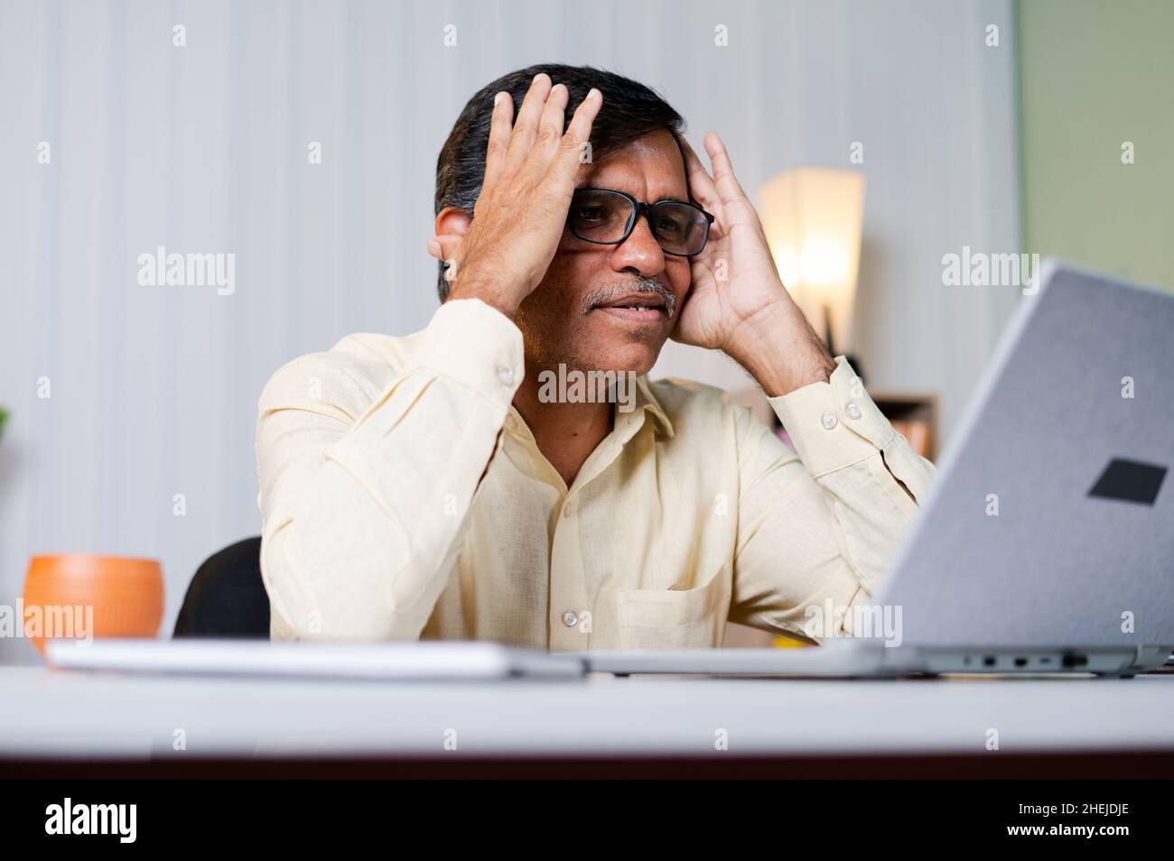 Middled aged Businessman got bad news or error while working on laptop at office - concept of cancelled business deal, network or internet connection Stock Photo