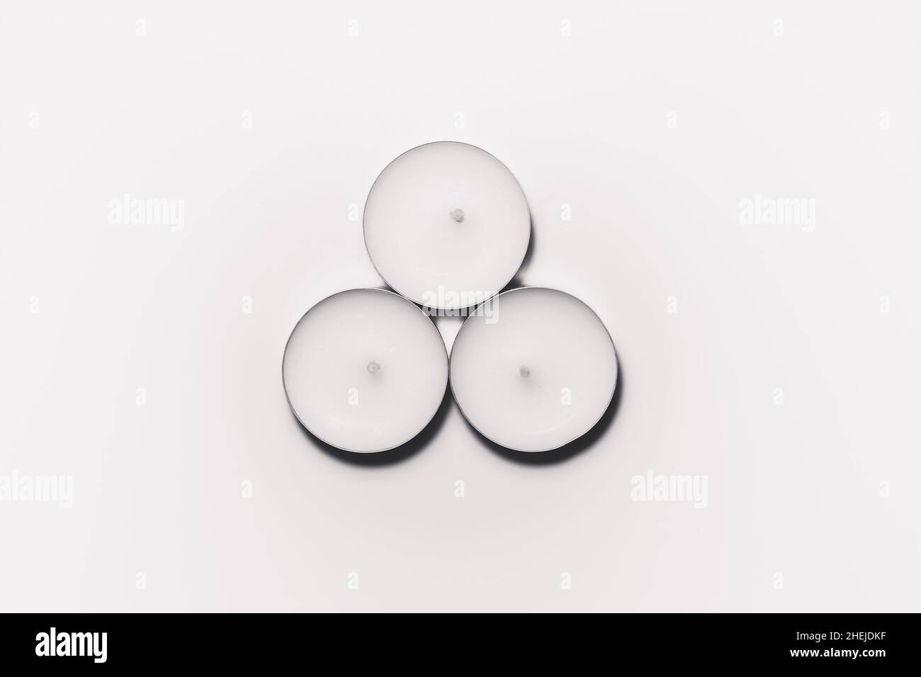 Monochrome white three tea light on white background top view Stock Photo