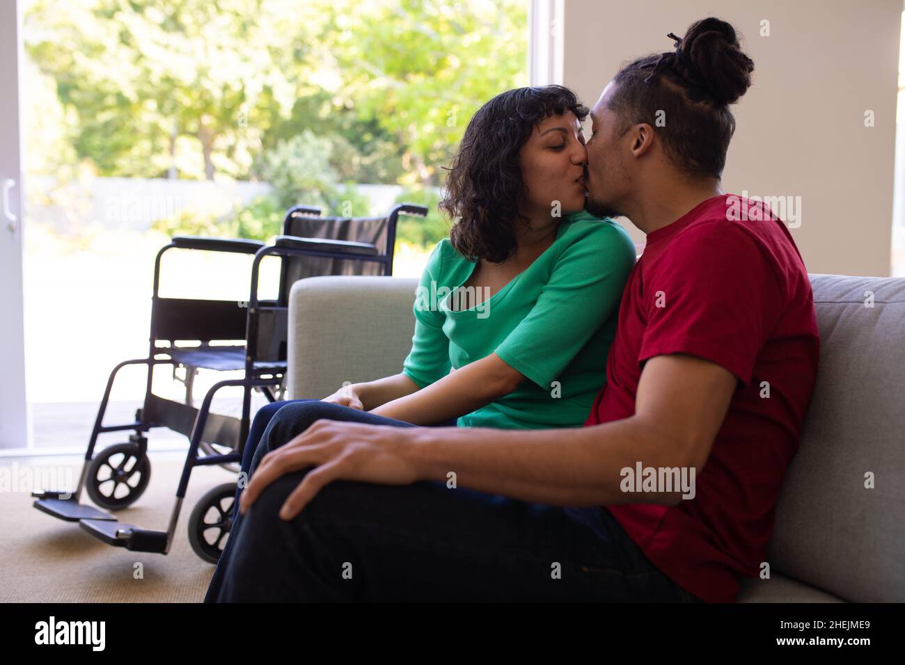 African american couple kissing while sitting on the couch at home Stock Photo