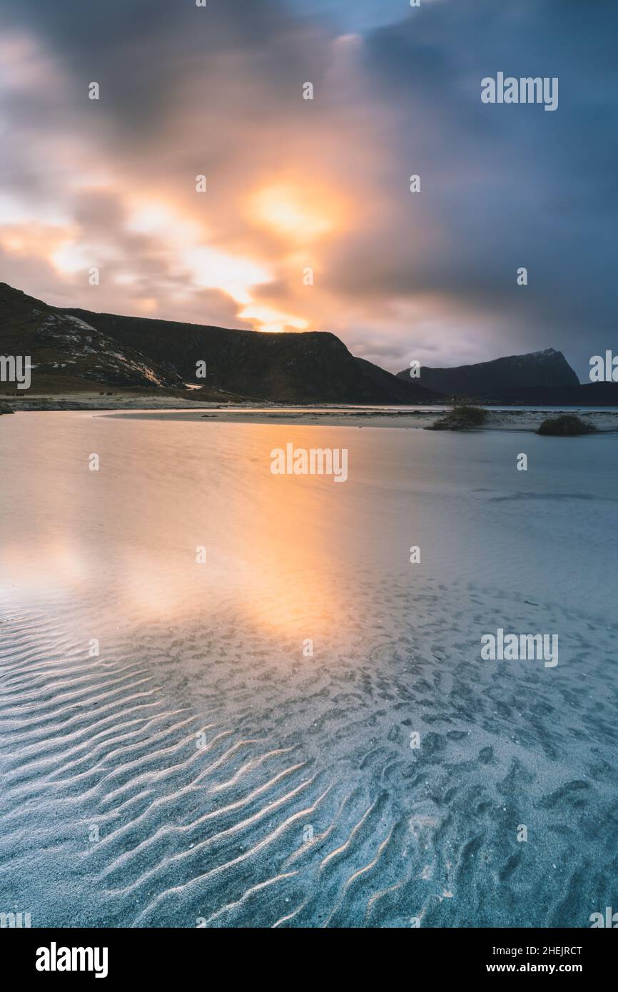 Sunrise light reflected in the cold transparent sea at Haukland beach, Leknes, Vestvagoy, Nordland, Lofoten Islands, Norway Stock Photo