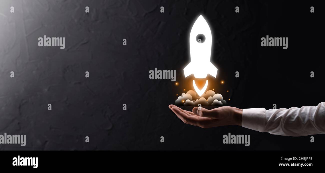 Startup business concept, Businessman holding tablet and icon rocket is ...