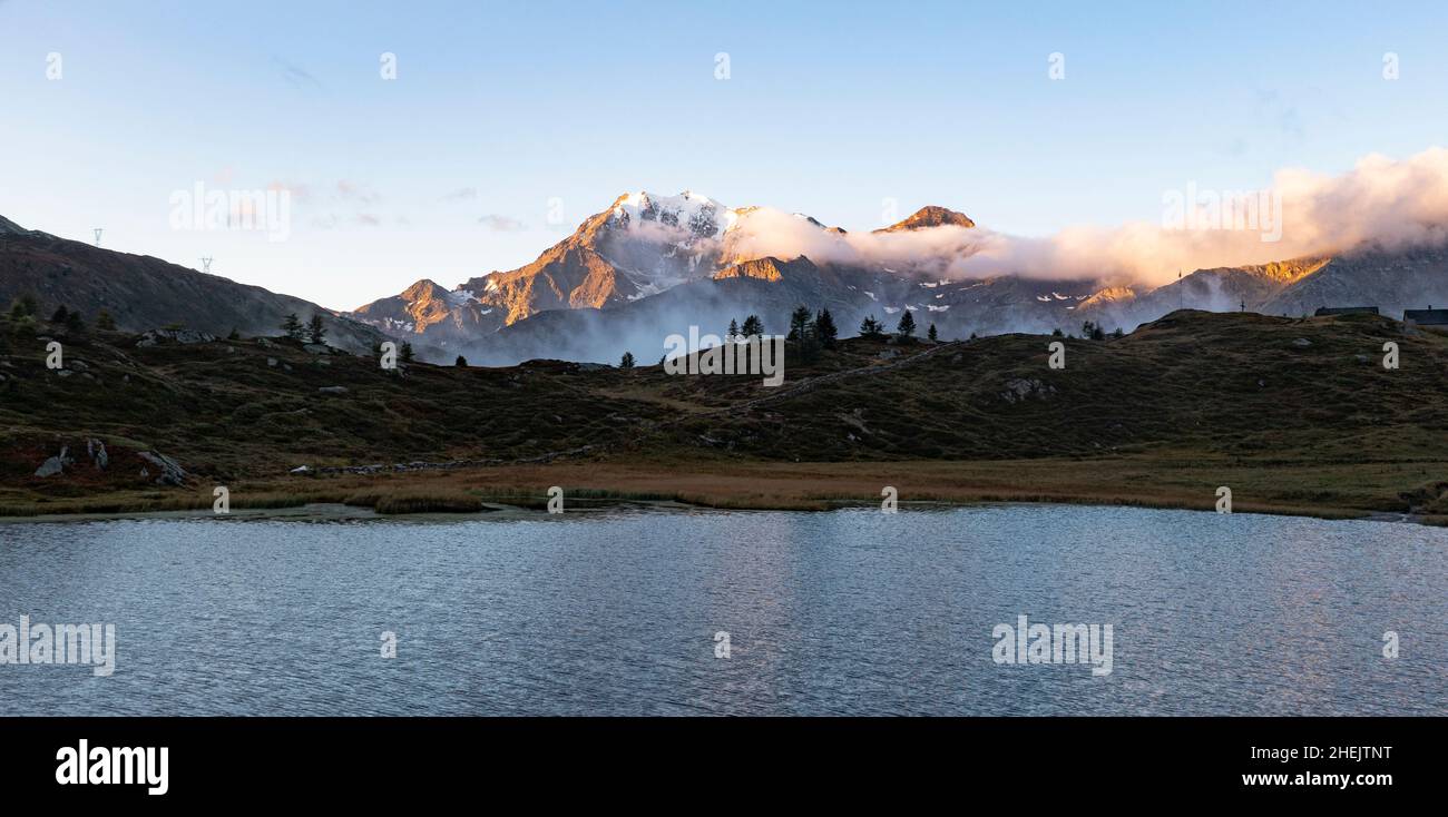 Aerial view of Fletschhorn and Galehorn peaks in mist at dawn from Hopschusee lake, Simplon Pass, Valais canton, Switzerland Stock Photo