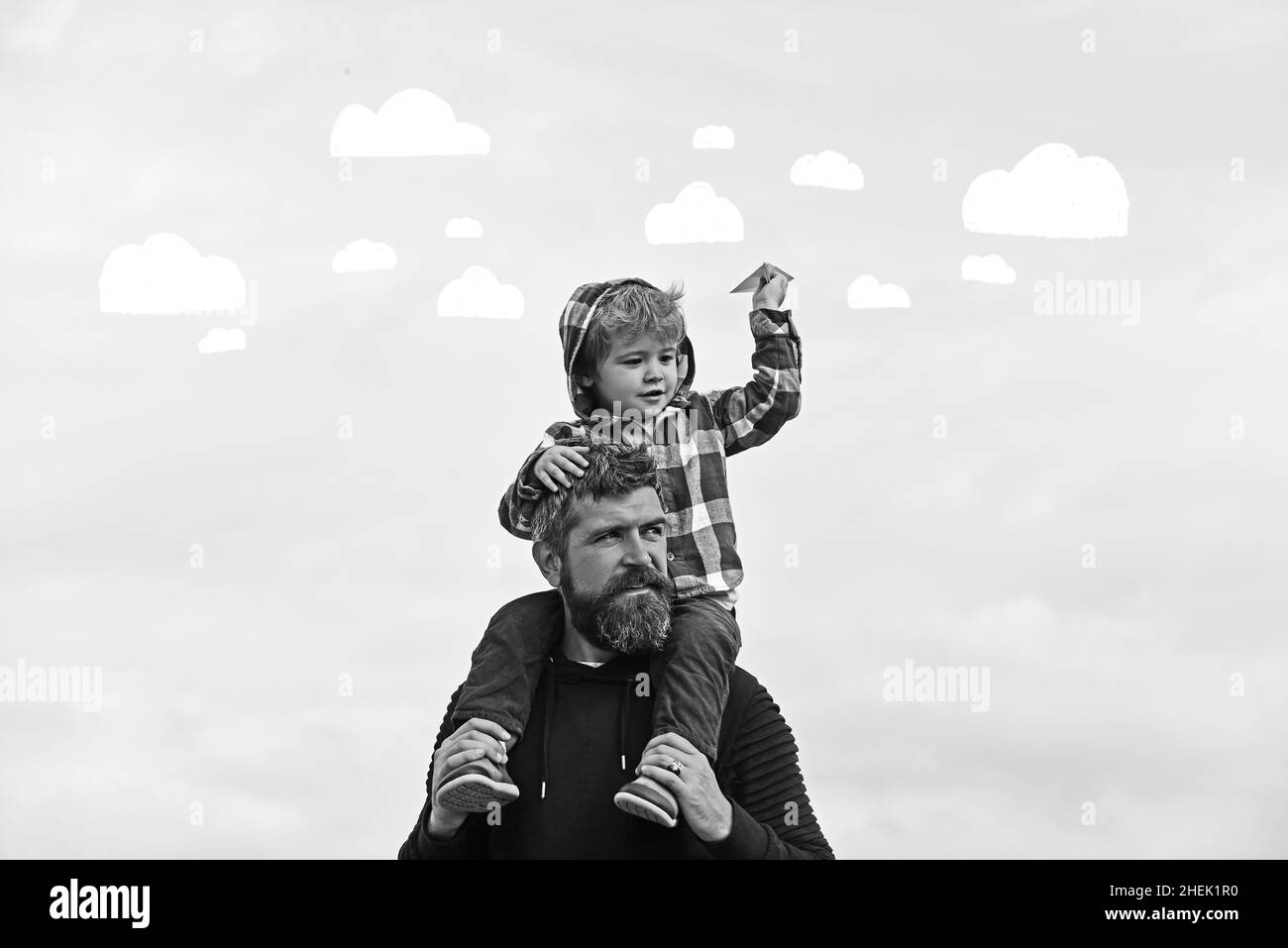 Father and son playing together. Father and his son child boy playing outdoors. Childhood. Freedom to Dream - Joyful Boy Playing With Paper Airplane. Stock Photo