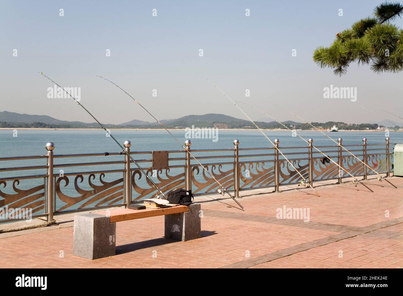 Five unattended fishing rods lined up along the promenade at Wolmido, Seoul, the capital of South Korea Stock Photo