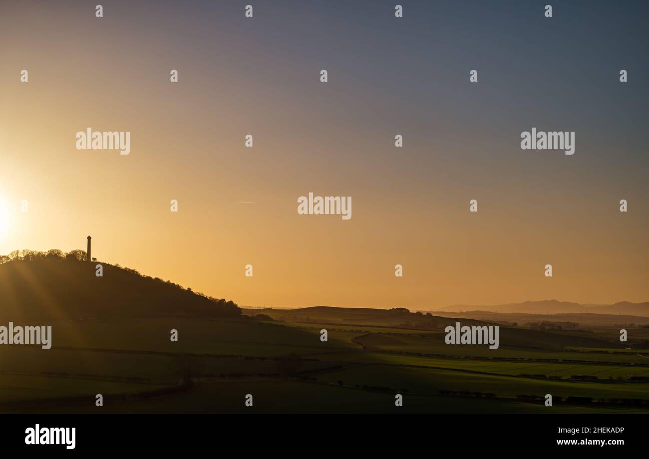 Hazy sunset with Hopetoun Monument hilltop tower silhouette, East Lothian, Scotland, UK Stock Photo