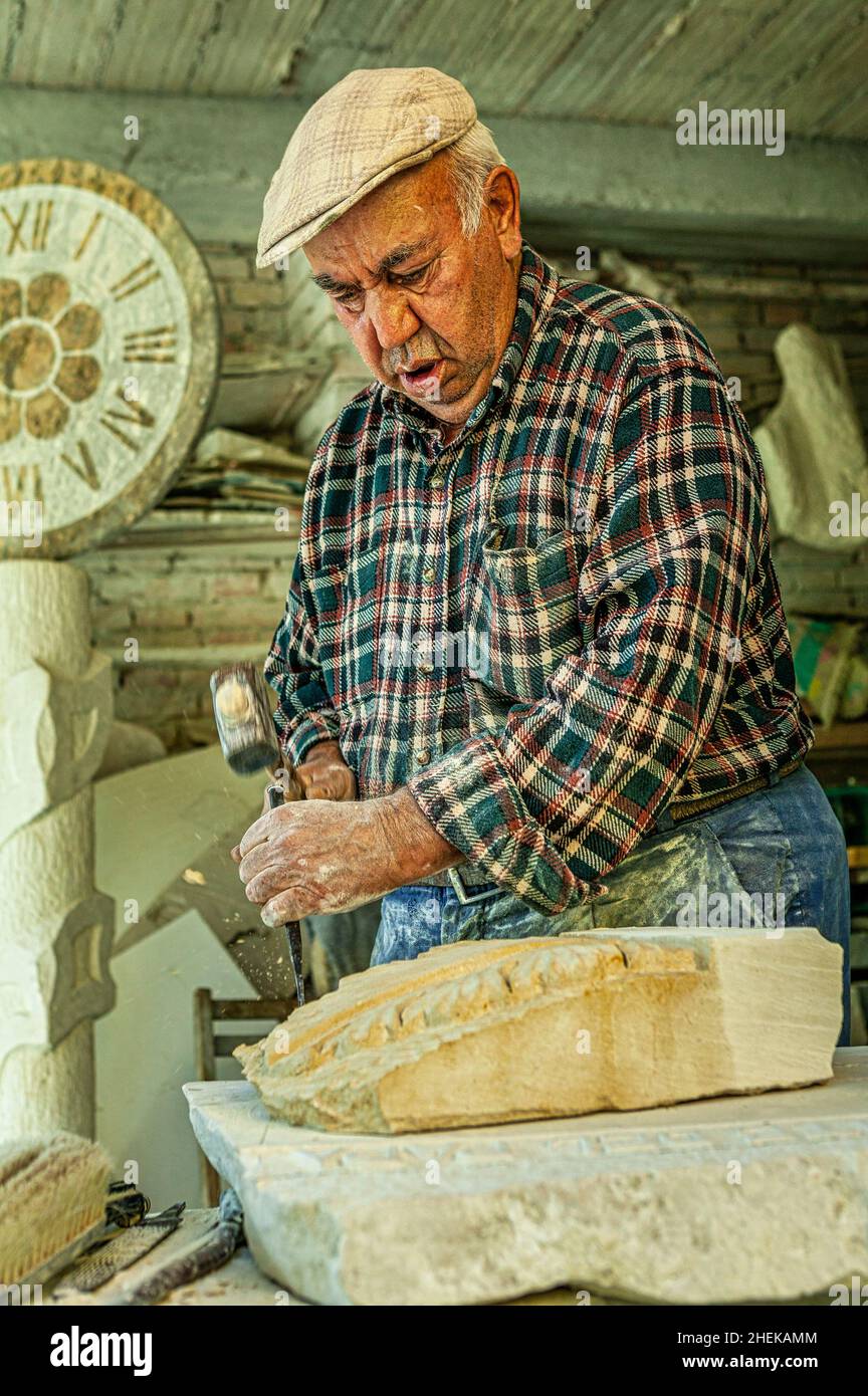 Stonemason at work on a stone sculpture. Creation of handcrafted decorations carved in the Maiella stone. Lettomanoppello, Pescara province, Abruzzo, Stock Photo