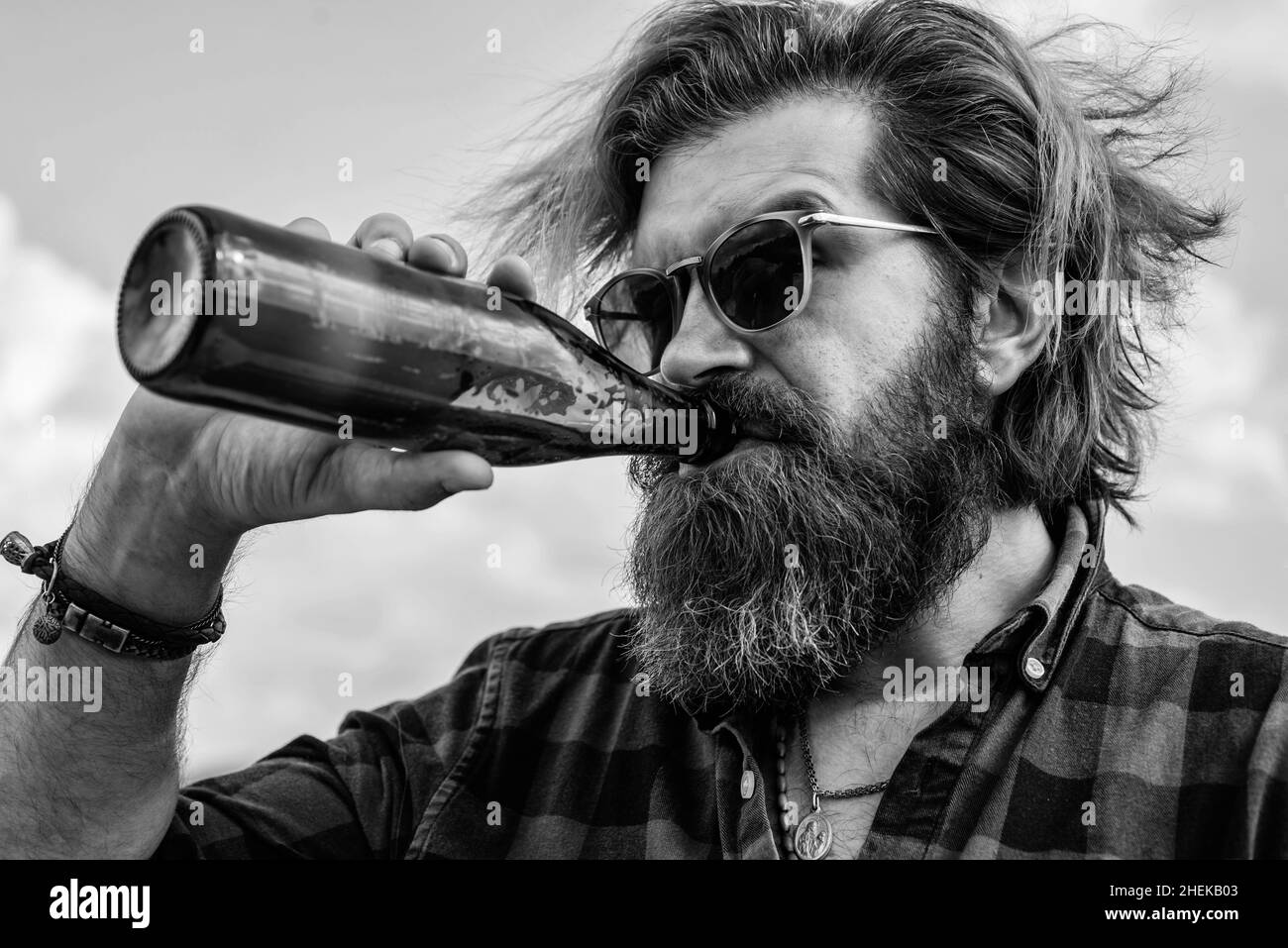 feeling thirsty. mature charismatic male drink beer from bottle. guy with beard and moustache outdoor. drinking beer from glass bottle. bearded man Stock Photo