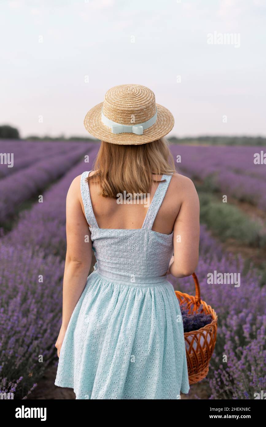 Back view portrait of stylish brunette woman in straw hat walking ...
