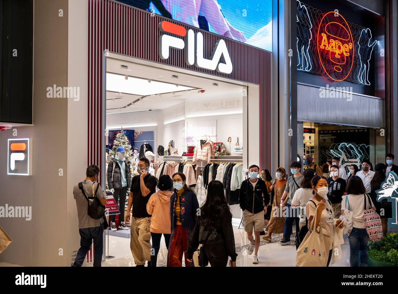 Shoppers walk past the Italian sporting goods brand, Fila and Japanese  fashion brand by A Bathing Ape, or BAPE, Aape stores in Hong Kong Stock  Photo - Alamy