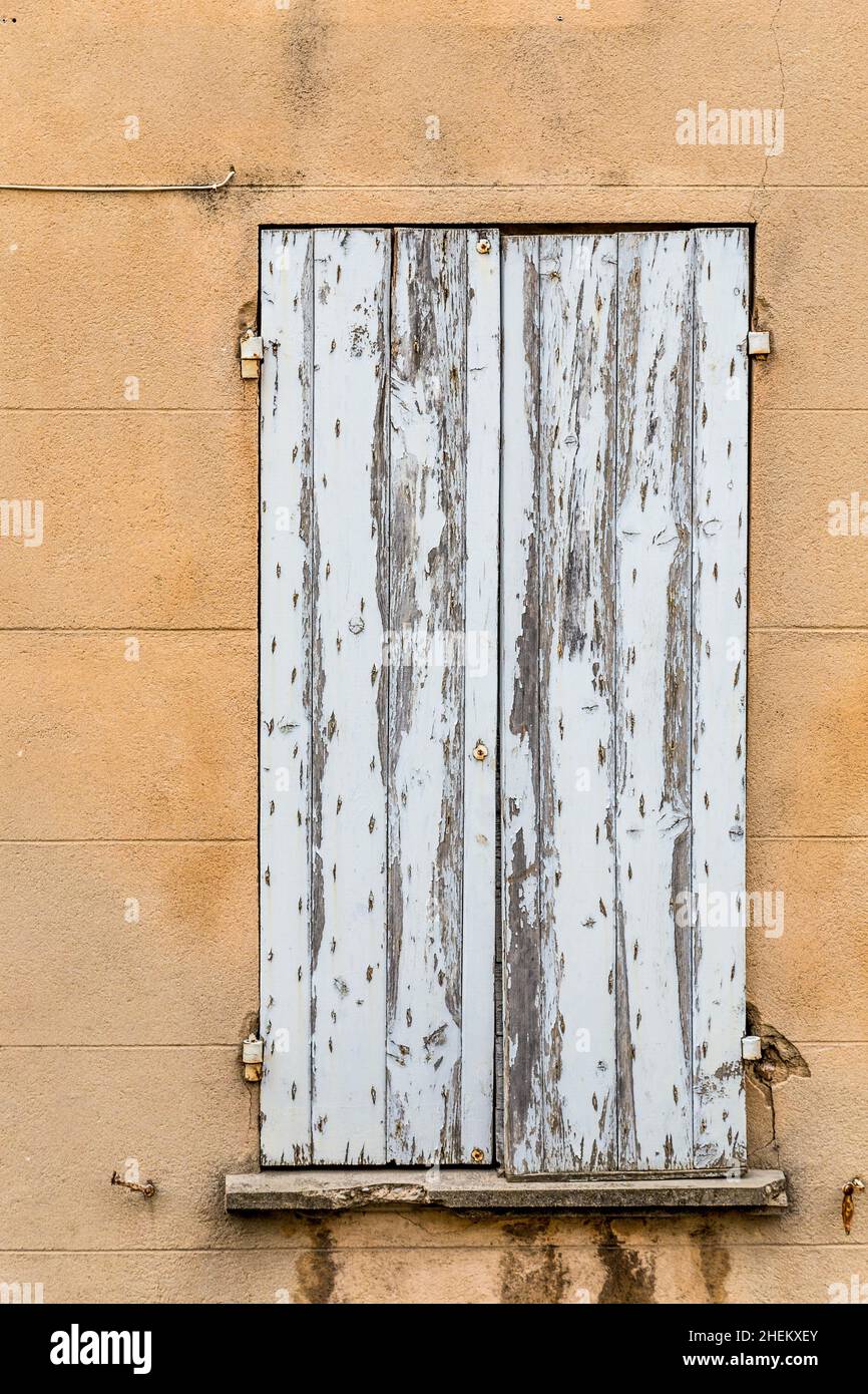 old rotten closed window with peeling white dirty paint as symbol for ...