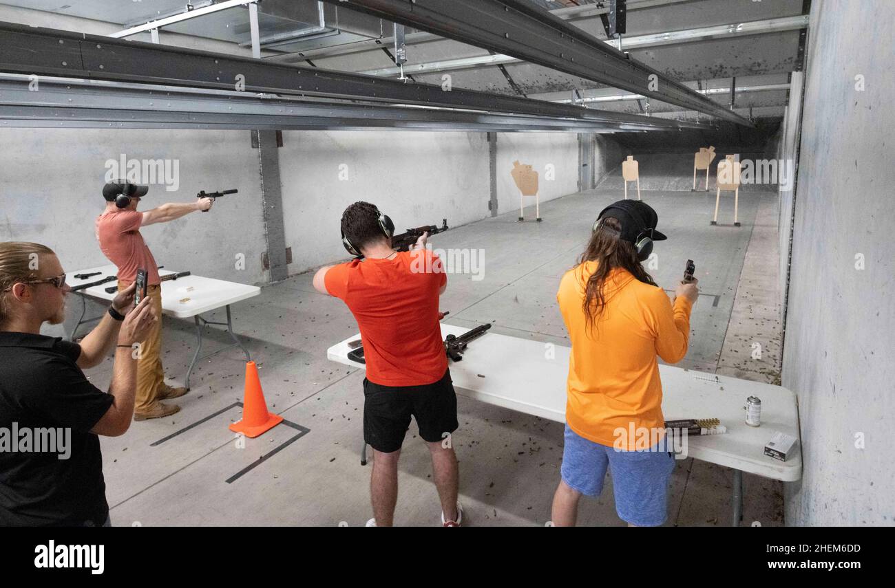 Austin Texas USA, October 23 2021: Bitcoin club members, supervised by the  range boss (left). shoot at The Range, an indoor shooting venue in south  Austin, during a club meet-up where members